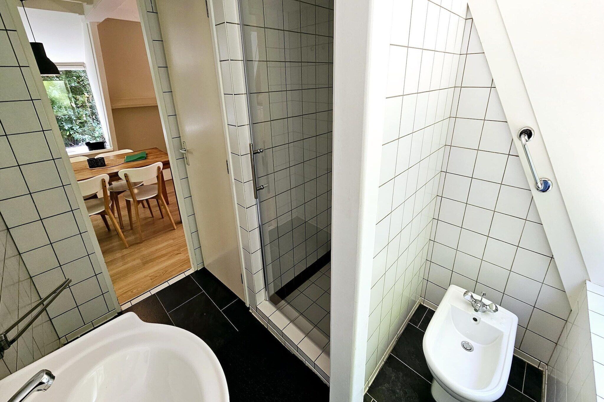 A bathroom with a bathtub, a shower, and a bidet.