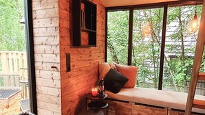 A cozy room with a wooden bench, a small table with a candle, and a basket of items. - Elegant Chalet Getaway in Ardennes (Durbuy)