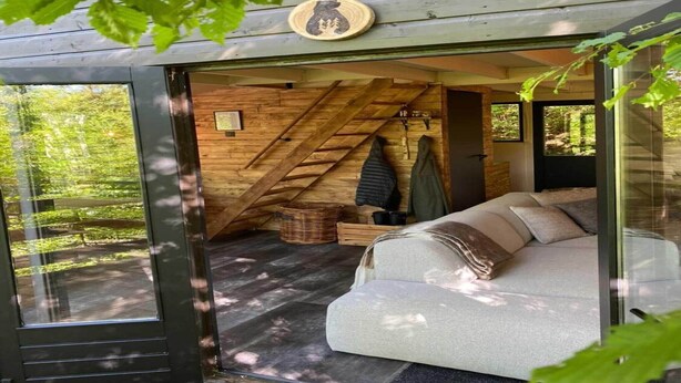 A cozy cabin interior with a wooden interior, a sofa, and a dining table. - Elegant Chalet Getaway in Ardennes (Durbuy)