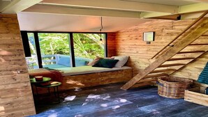 A cozy room with a built-in bench, a small table, and a wicker basket. - Elegant Chalet Getaway in Ardennes (Durbuy)