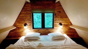 A bedroom with a sloped ceiling, a large window, and two wall-mounted lights. - Elegant Chalet Getaway in Ardennes (Durbuy)