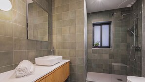 Et moderne badeværelse med badekar, brusekabine og toilet.
