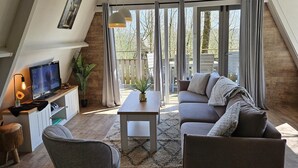 Ein modernes Wohnzimmer mit Fernseher, Sofa und Couchtisch.