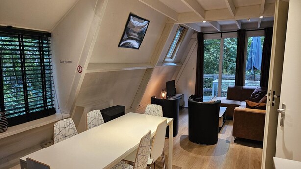 Ein modernes Interieur mit Essbereich, Kamin und Blick ins Freie.