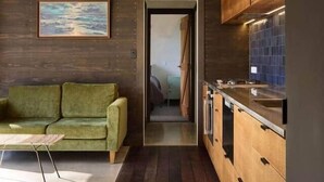 Een moderne keuken met houten kastjes en uitzicht op de eethoek.