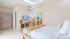 Een slaapkamer met een bed, nachtkastjes, een televisie, een lamp en een garderobe.