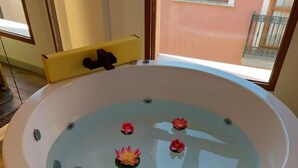 Eine runde Badewanne mit Glasabdeckung, Seerosen und einem gelben Stuhl.