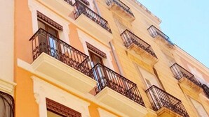 Ein mehrstöckiges Gebäude mit Balkonen, Nummer 33, in klassizistischer Architektur mit aufwendigen Geländern.