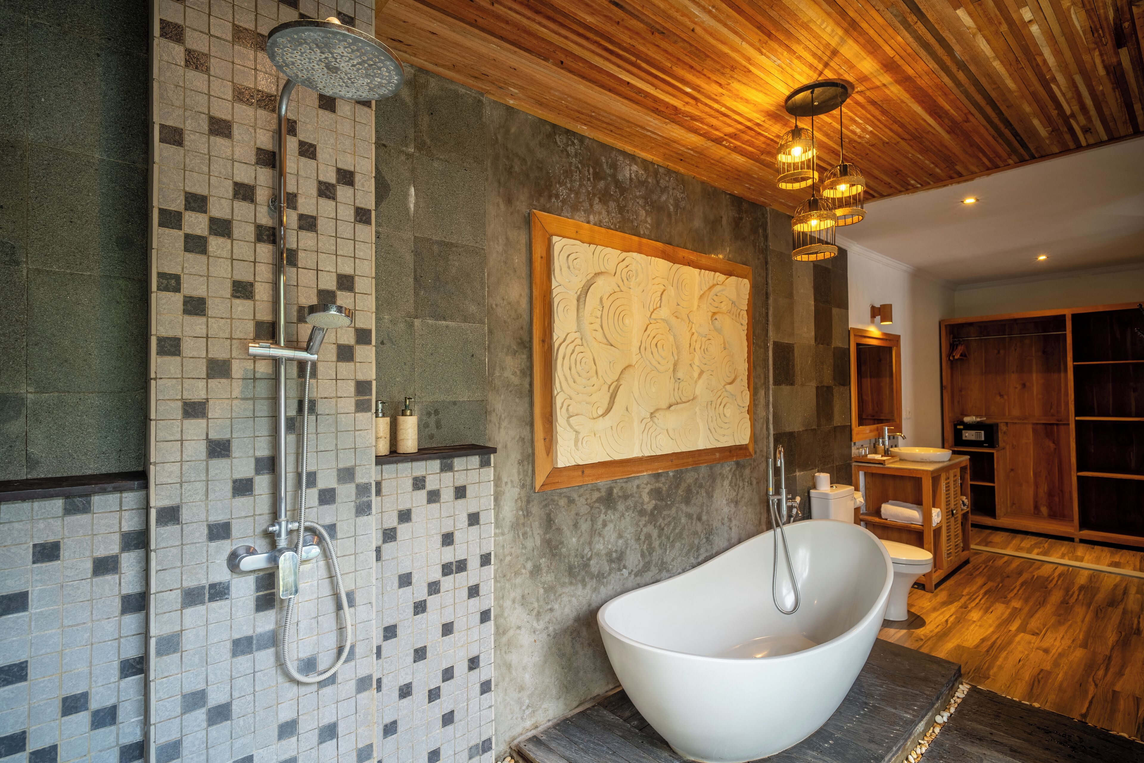 Un baño moderno con una bañera independiente, un cabezal de ducha y una pared de mosaicos.