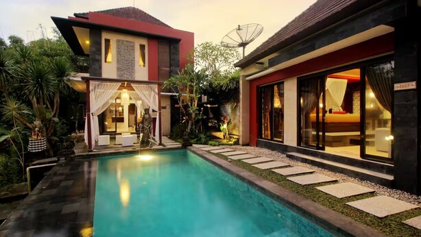 Une maison moderne dotée d’une piscine, d’un espace salon extérieur abrité et d’une antenne parabolique.