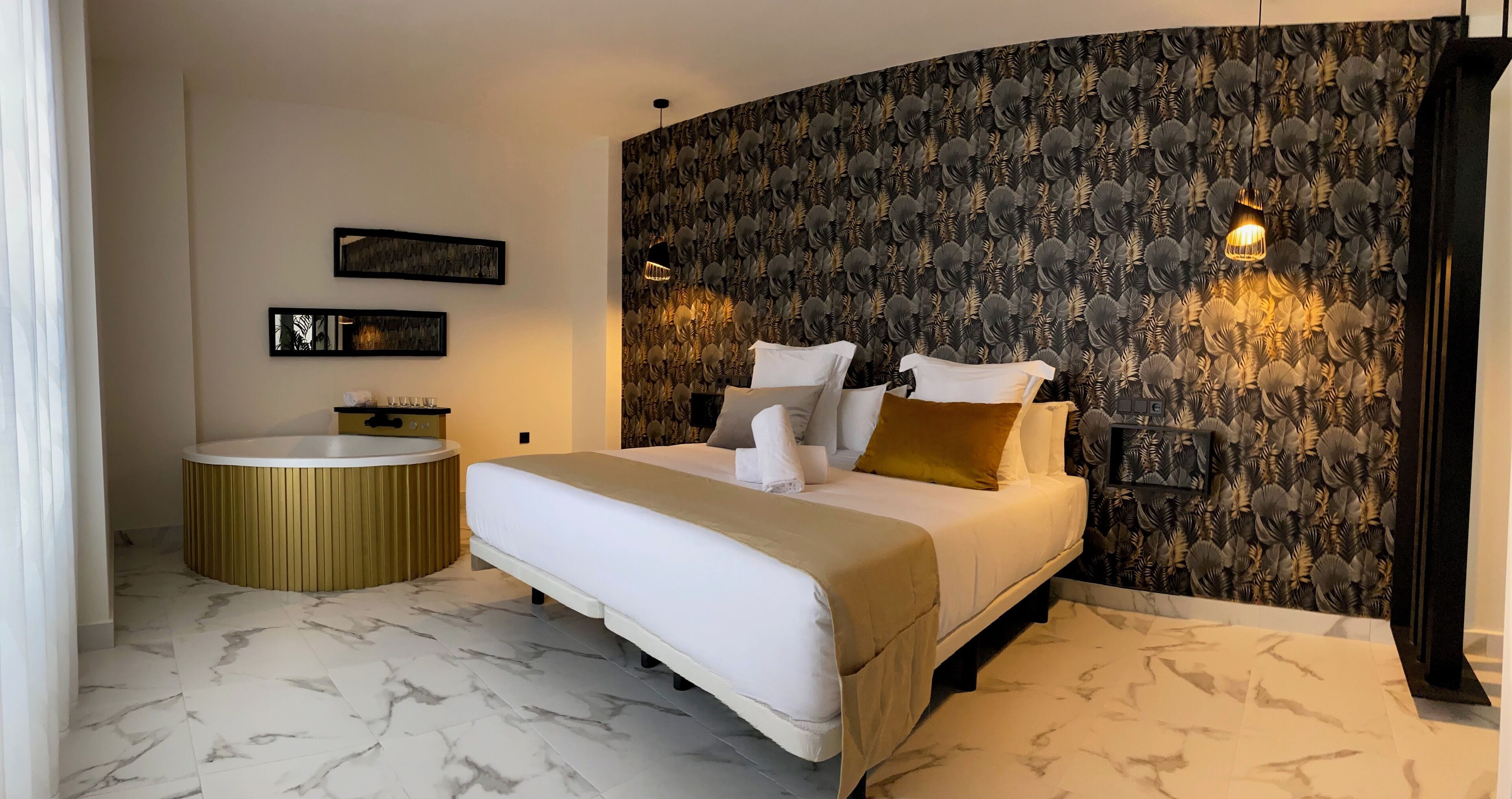 A modern bedroom with a curved bed, a round bathtub, and a patterned wallpaper.