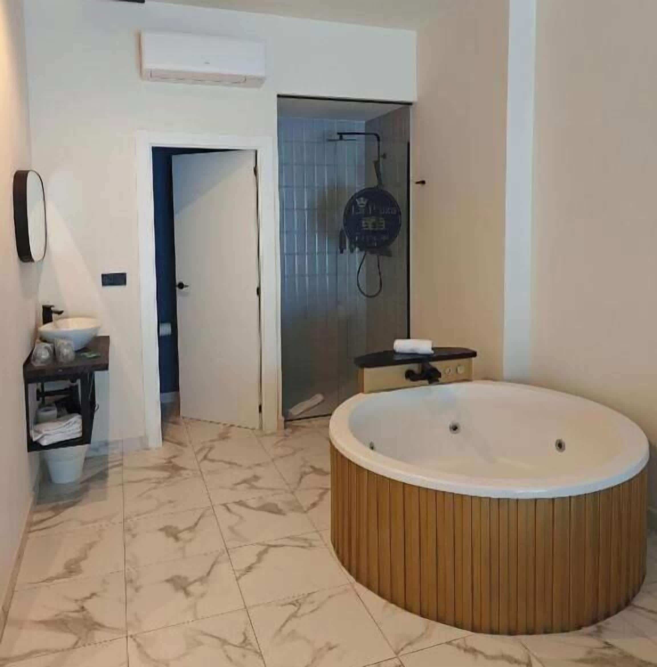 Un baño moderno con una bañera independiente, zona de ducha y tocador con lavamanos.