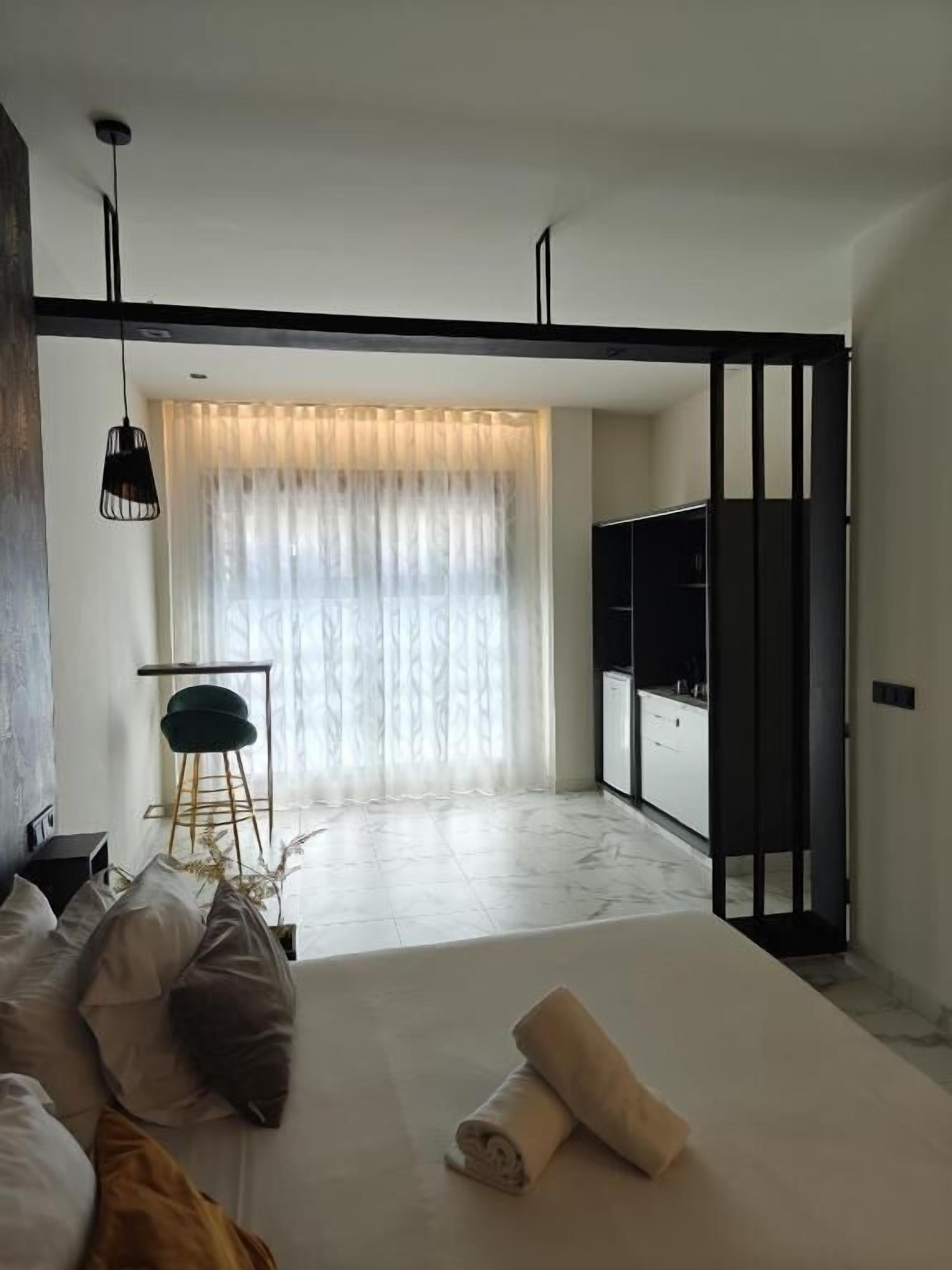 Et moderne hotelværelse med seng, skrivebord og garderobe.