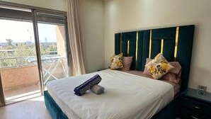 Un dormitorio con una cama grande, una mesita de noche, una lámpara en el techo y vistas al exterior.