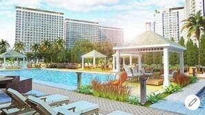 Ein Hotel mit Schwimmbad, Liegestühlen und einem Pavillon.