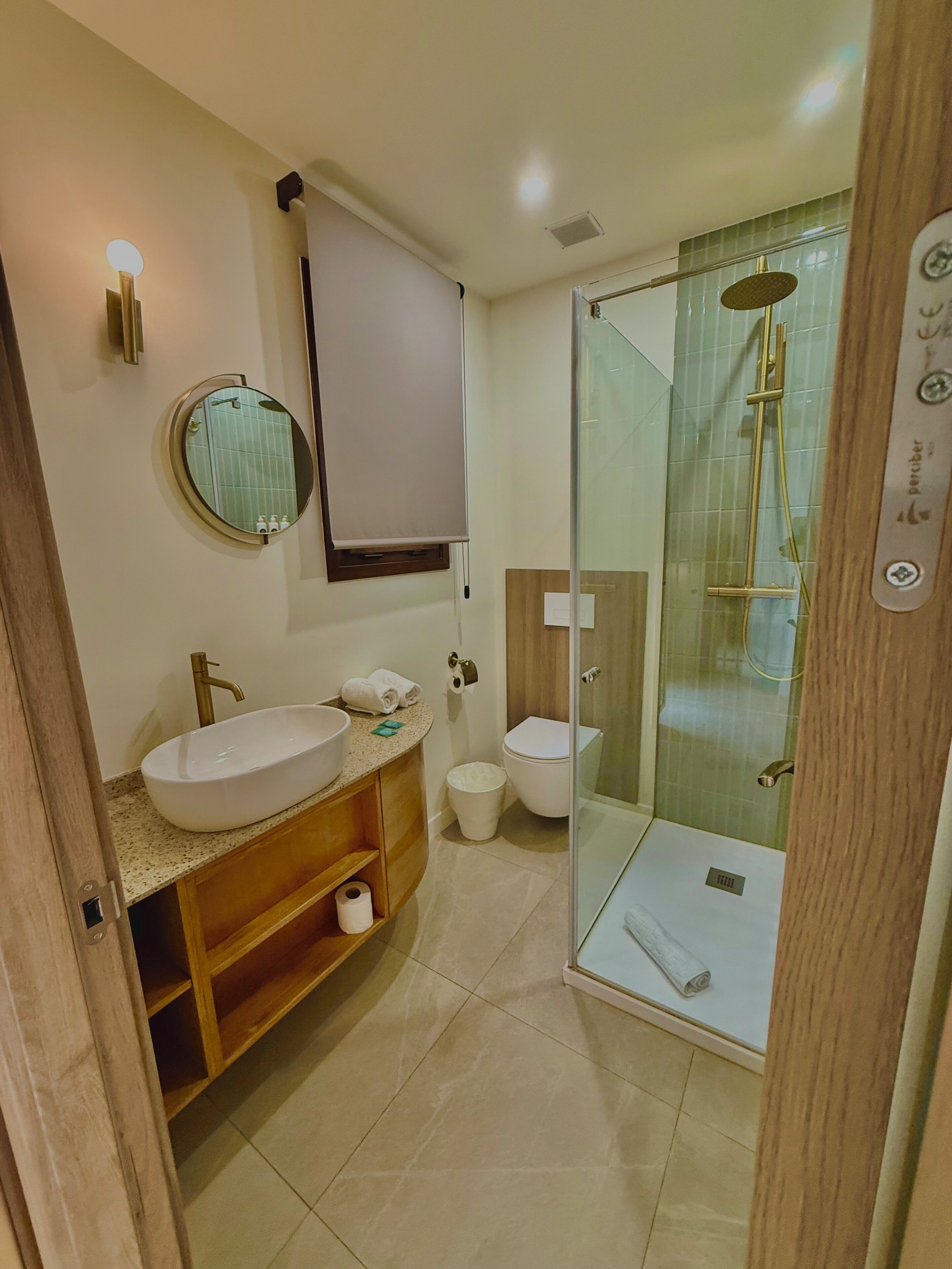 A modern bathroom with a freestanding sink, toilet, and glass-enclosed shower.