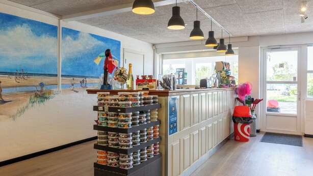 A beach-themed mural, a candy display, and a counter with various items. - Rømø familiecamping (Rømø)