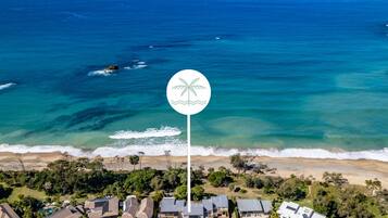 Vista aérea de una zona residencial costera con casas, una playa y el océano.