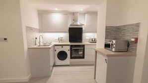 Cocina compacta con lavadora, horno y microondas.