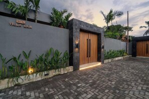 A modern villa with a paved driveway, a wooden door, and a nameplate reading 'Villa Laia'. - Villa Laia by BaliSuperHost (Bali)