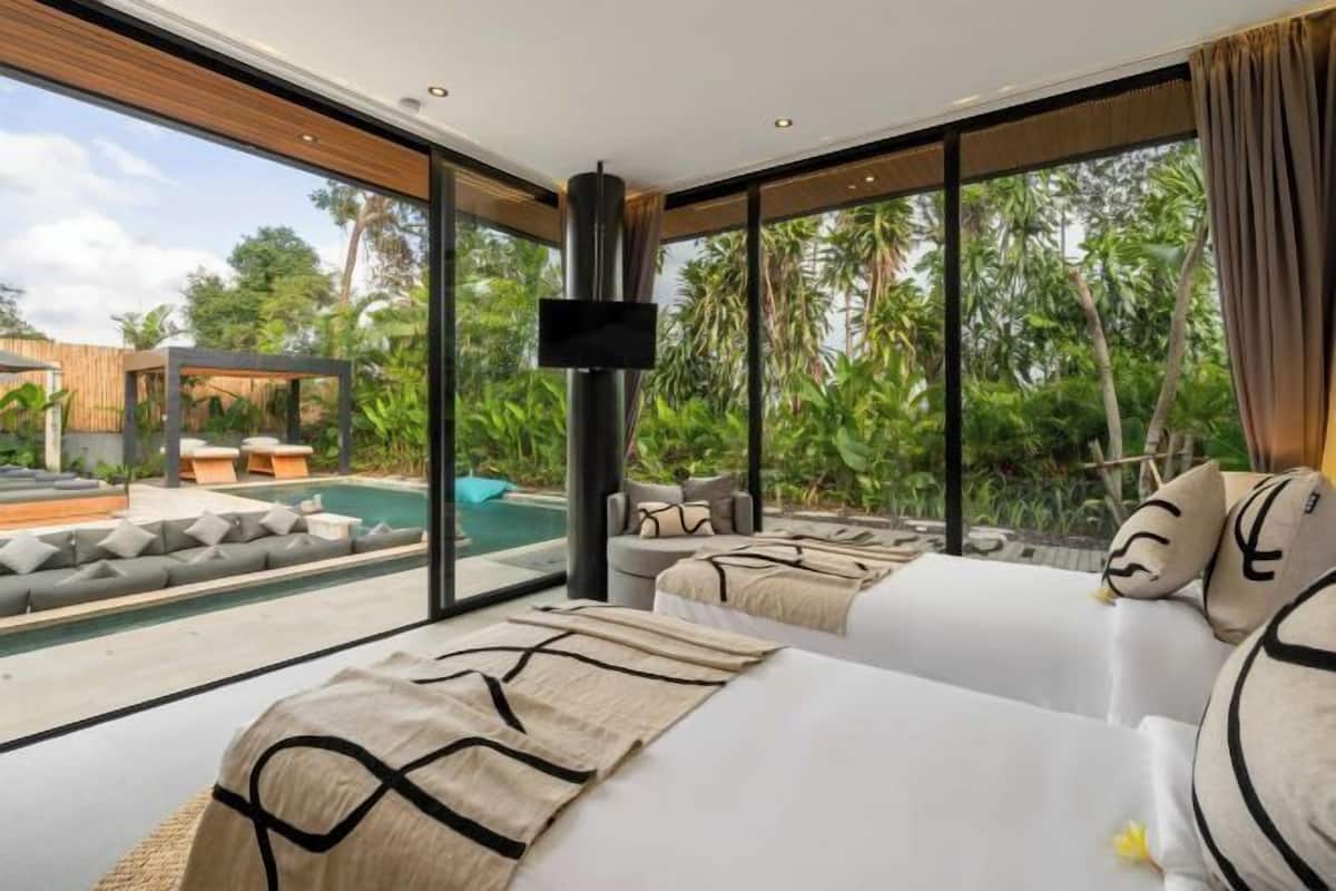Quarto moderno com uma grande janela, piscina e área de estar externa.