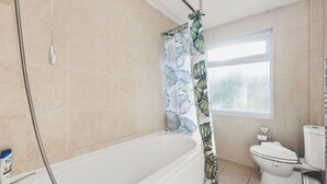 Ein Badezimmer mit Badewanne, Toilette und Duschvorhang.