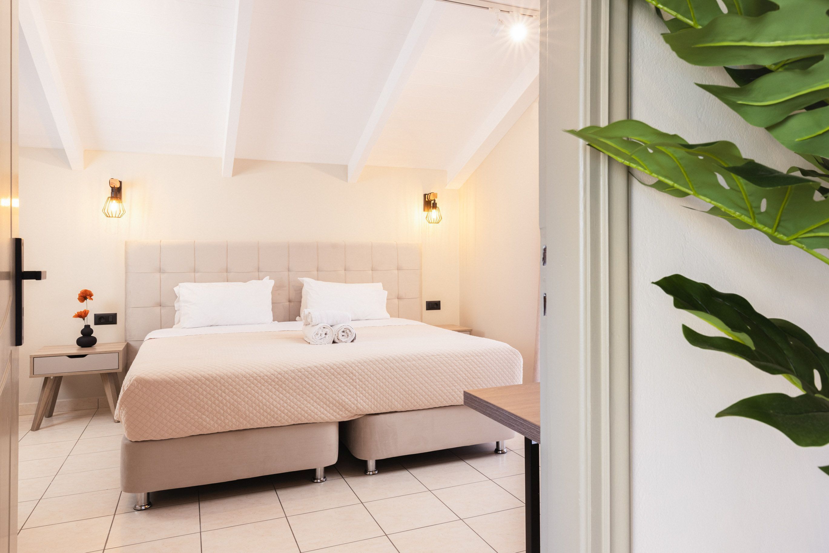 Een slaapkamer met een groot bed, nachtkastjes en wandlampen.