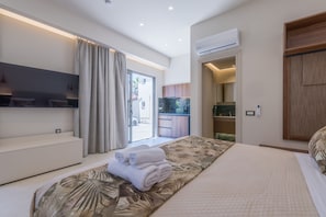 Une chambre d’hôtel moderne équipée d’un lit, d’un coin salon, d’une télévision et offrant une vue sur l’extérieur.