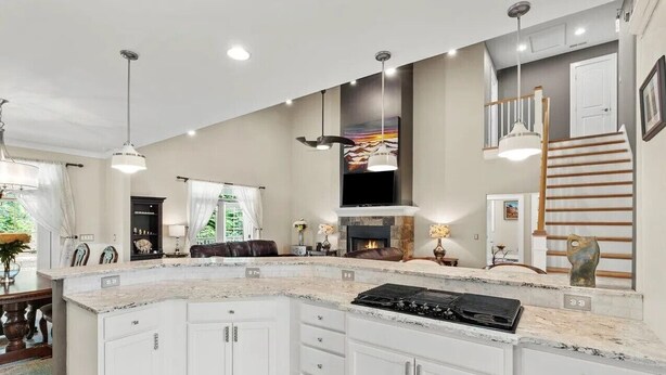A spacious kitchen with a large island, built-in cabinets, and a modern stove.