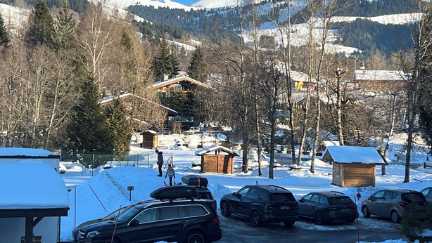A snowy mountain village with cabins and parked cars. - Studio rental at the foot of the slopes (Megève)