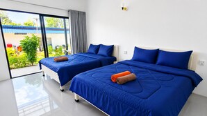 Ein Hotelzimmer mit zwei Betten, einem großen Fenster und Blick auf Grün.