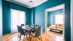 Un coin repas avec une table en verre, des chaises et une plante en pot.