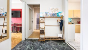A hallway with a wooden ladder, a shelf with books and a globe, and a red wall in the background. - Sunny Cozy 3bd apt Just a min Away to Acropolis (Athens)