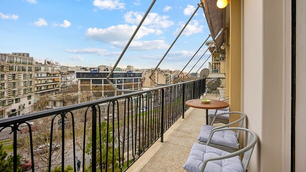 A balcony with a view of a cityscape, a small table, and two chairs. - Sunny Cozy 3bd apt Just a min Away to Acropolis (Athens)
