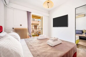 Une chambre d’hôtel avec un lit, une télévision, un balcon et une vue sur l’extérieur.