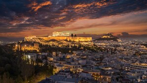 A panoramic view of a city with a prominent ancient citadel on a hill, surrounded by dense urban development. - Sunny 3bd Cozy Flat Spectacular Acropolis View (Athens)