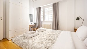 Un dormitorio con cama, escritorio y armario.