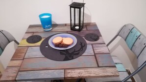A square table with a rustic design, a blue cup, a black lantern, and a plate with cookies. - Sunny 1bd Apartment Just 1minute to Acropolis (Athens)