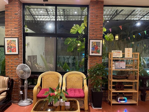 A cozy seating area with wicker chairs, a fan, and a table with a plant. - Kravan Siem Reap Boutique Villa (Siem Reap)
