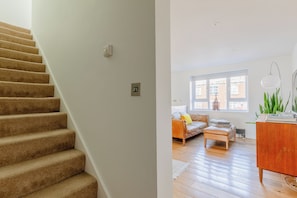 A staircase with carpeted steps and a wall-mounted light switch. - Chic 1BDR City Retreat with Views of the Shard (Greater London)