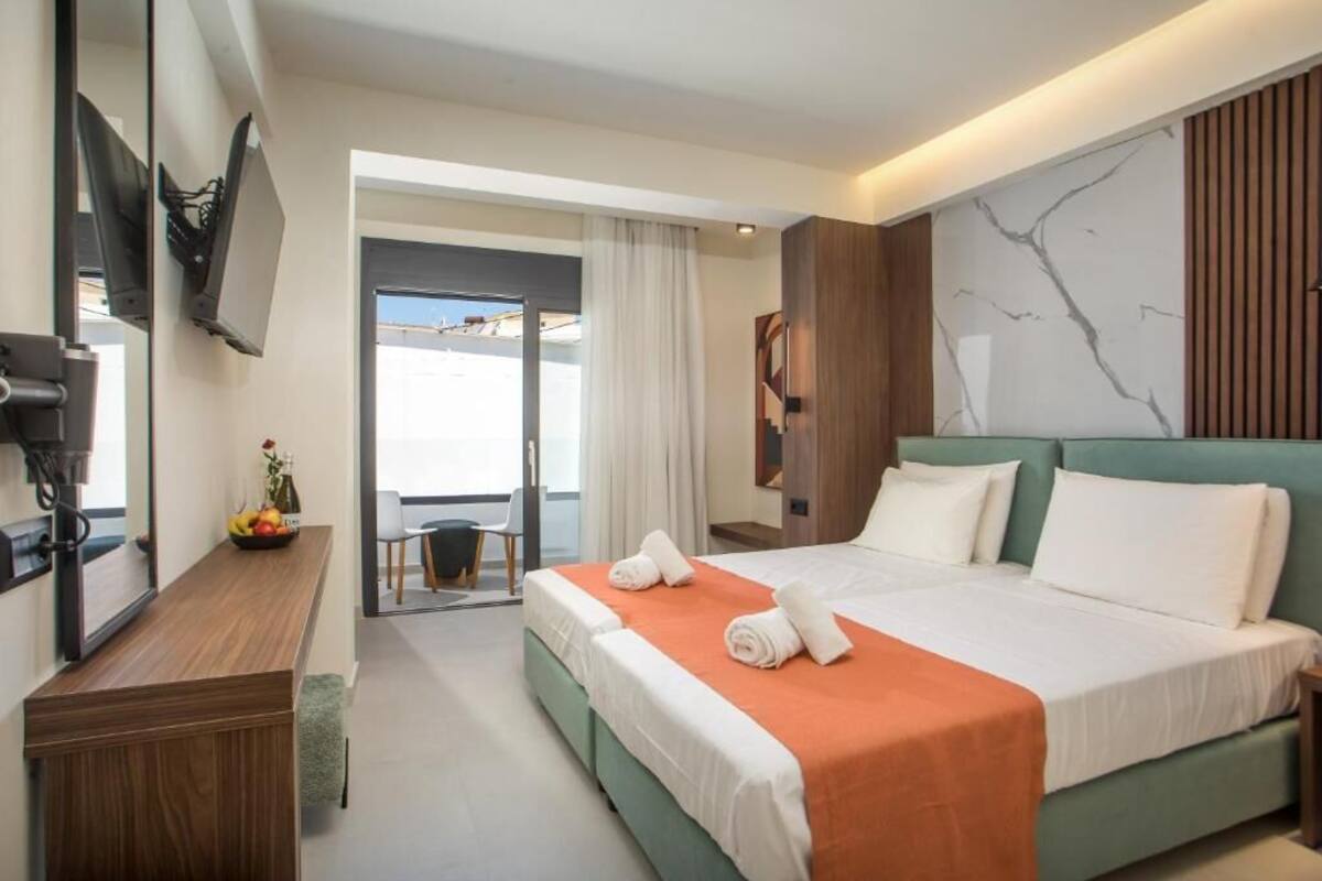 Una habitación de hotel moderna con una cama grande, un escritorio y una televisión.