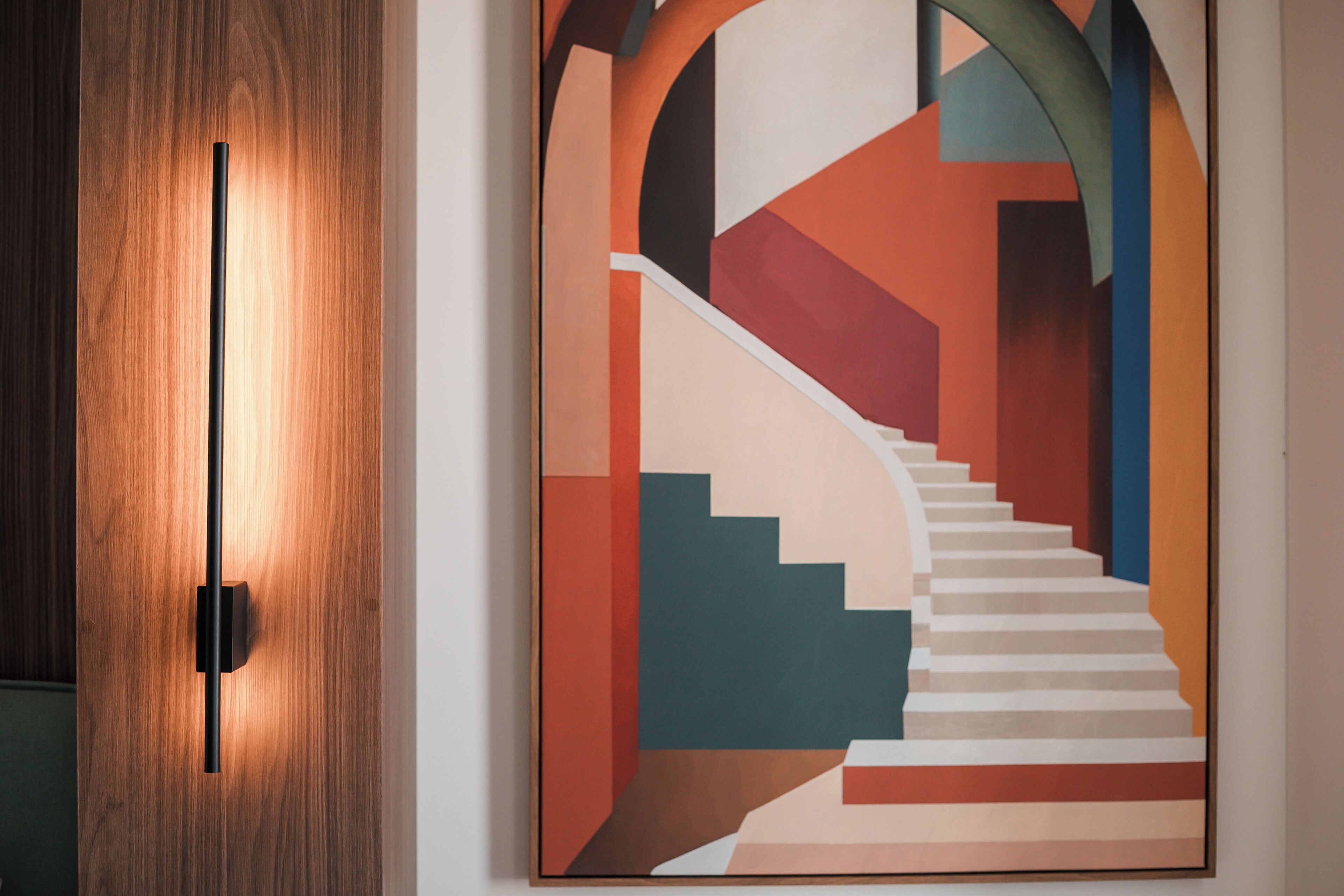 A modern interior with a wooden door and a geometric art piece depicting a staircase.