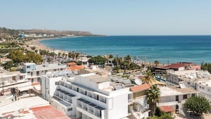 Un pueblo costero con playa, edificios y una vista despejada del mar.