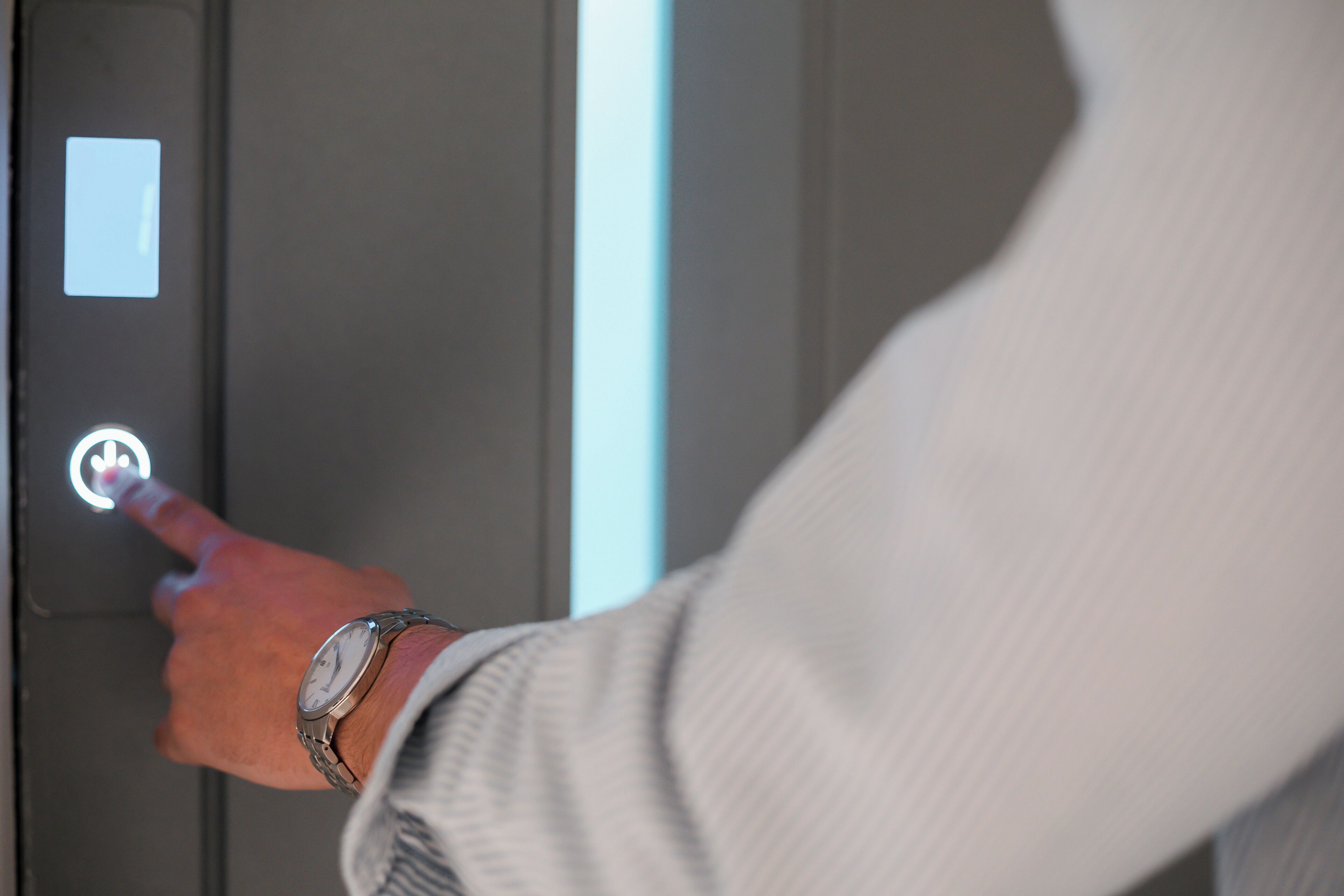 A person using a touchpad to operate an elevator.