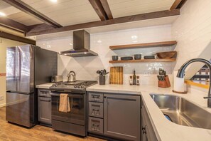 Eine moderne Küche mit Edelstahlgeräten, Holzschränken und einem eingebauten Backofen.