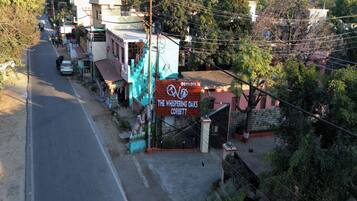 Vista callejera con un cartel que indica 'The Whispering Oaks Corbett' hotel.