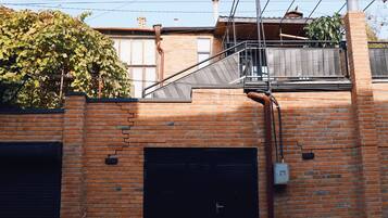 A brick building with two garage doors, a metal staircase, and a power line overhead.