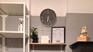 A kitchen with a clock, a coffee machine, a bottle of wine, and a bag of snacks. - La Mia Roma house-Charme Comfort & Relax-close subway-5 minutes from Colosseum (Roma)
