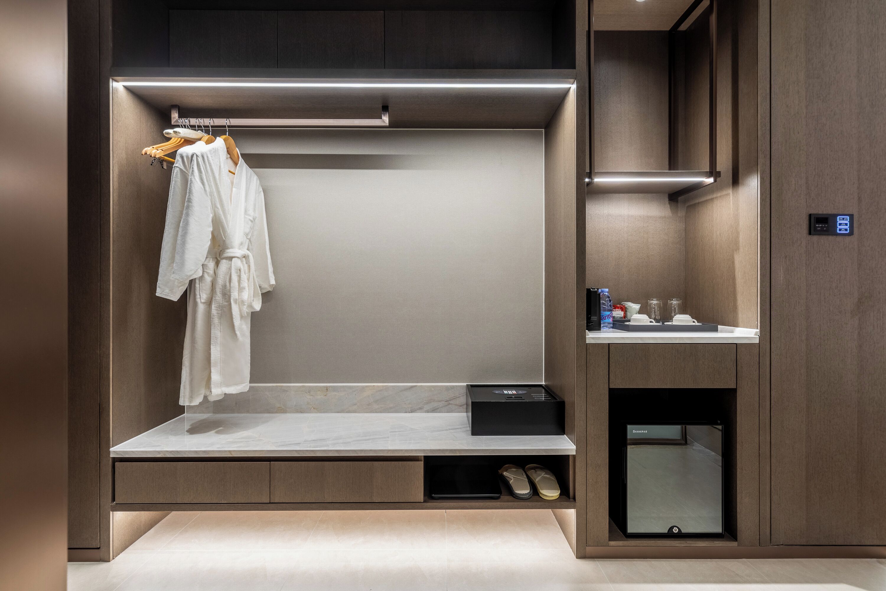 Un baño moderno con tocador empotrado, perchero y espacio para guardar zapatos.