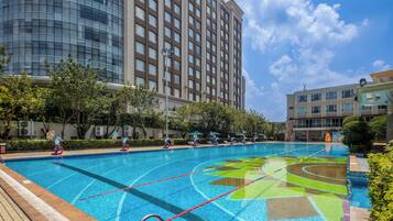 Una piscina techada, una piscina al aire libre de temporada, sombrillas
